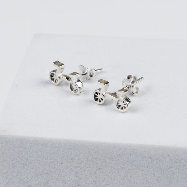 Silver bicycle-shaped earrings on white background