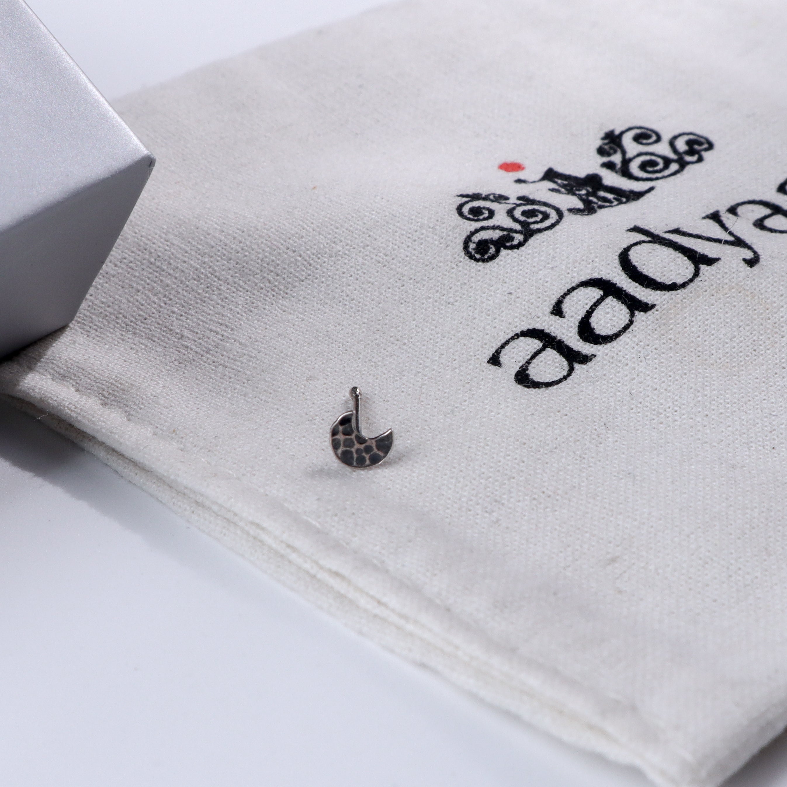 Silver hammered crescent nose pin on Aadyaa jewelry pouch