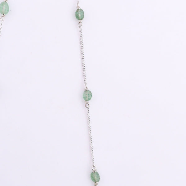 Silver chain with green quartz beads on white background