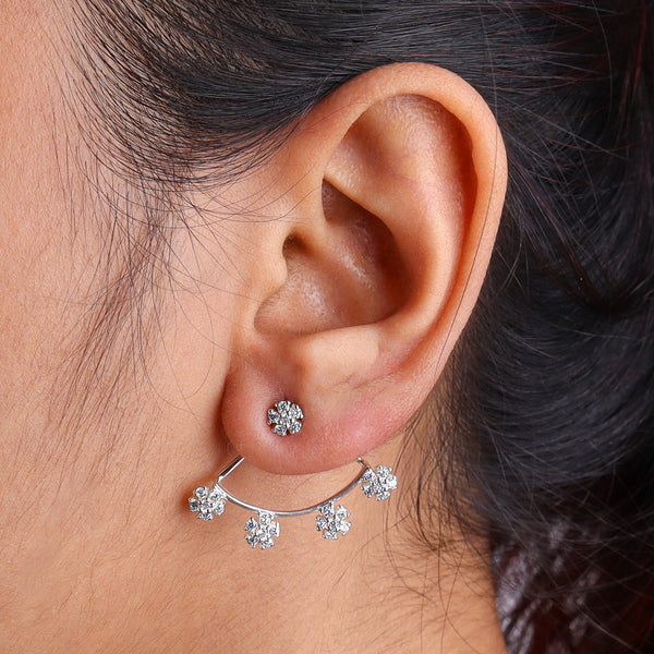 Close-up of silver flower CZ earrings worn on ear, side view