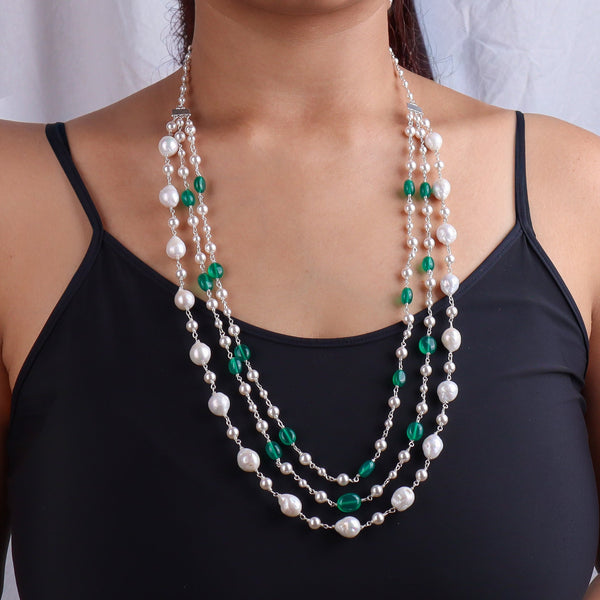 Necklace with freshwater pearls and green onyx beads worn on a woman