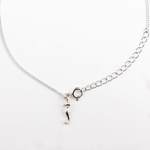 Close-up of silver seahorse charm anklet detailing
