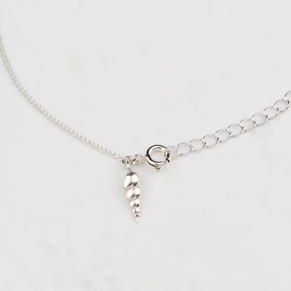 Close-up of silver auger shell charm anklet detailing