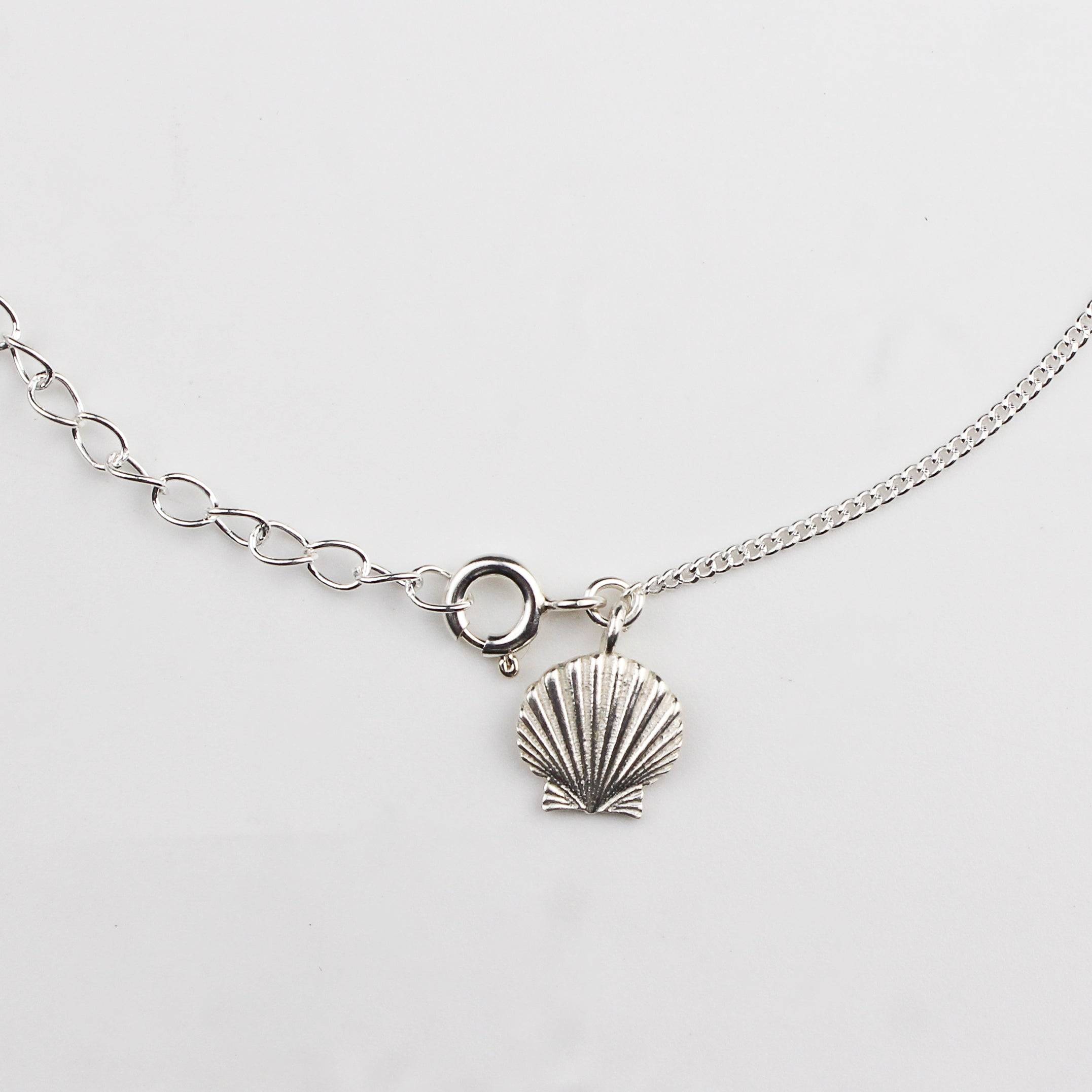 Close-up of silver shell charm anklet detailing