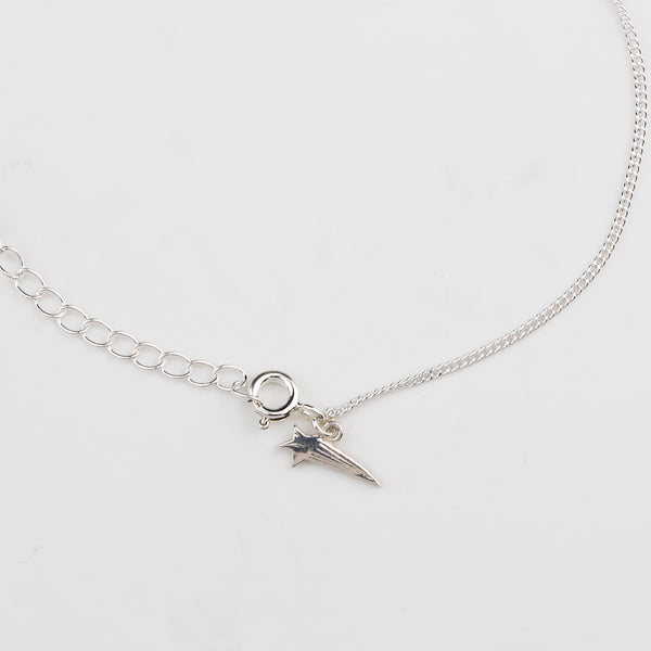 Close-up of silver shooting star charm anklet detailing