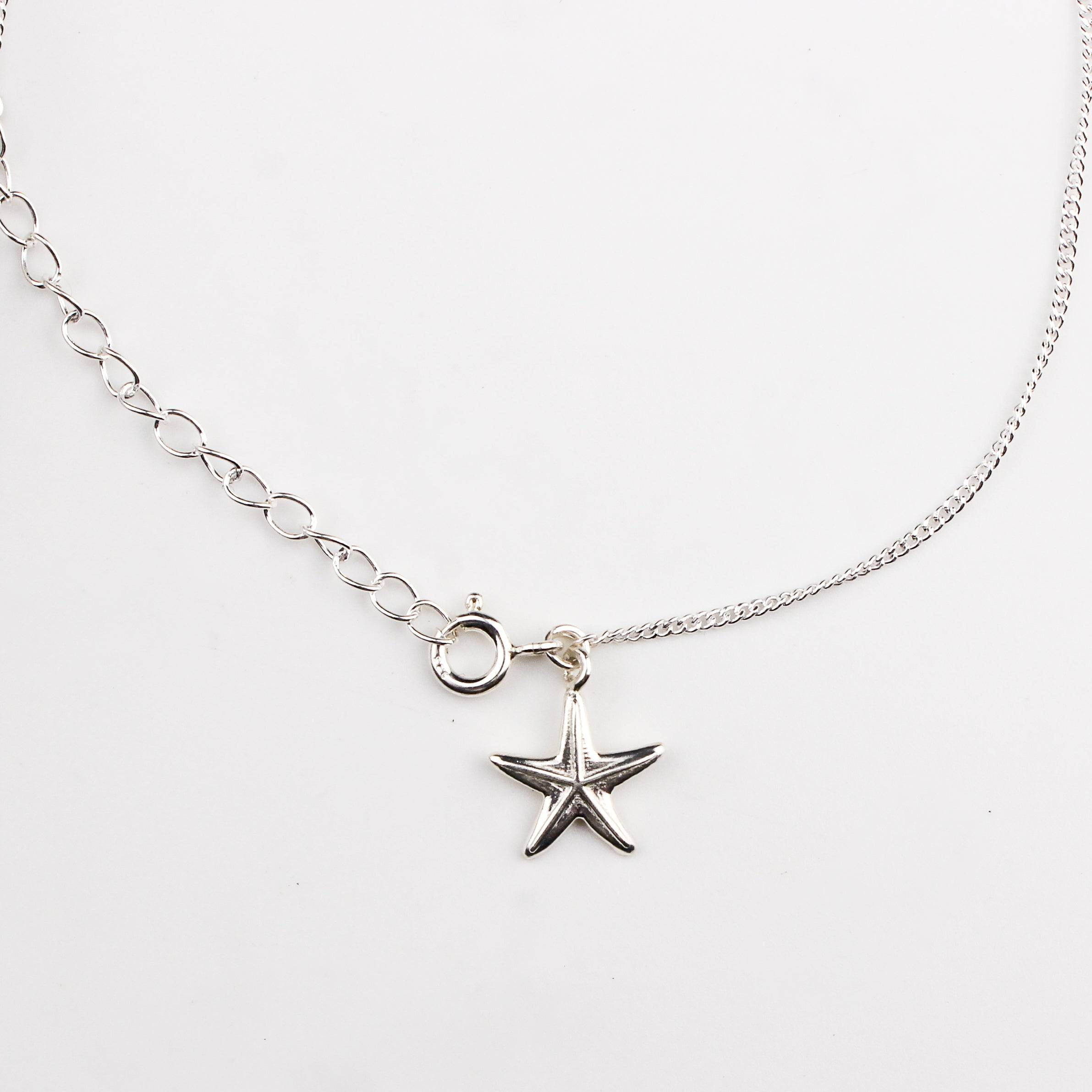 Close-up of silver starfish charm anklet detailing