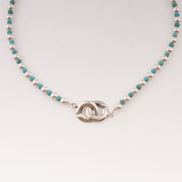 Close-up of pearl and turquoise necklace with infinity lock clasp
