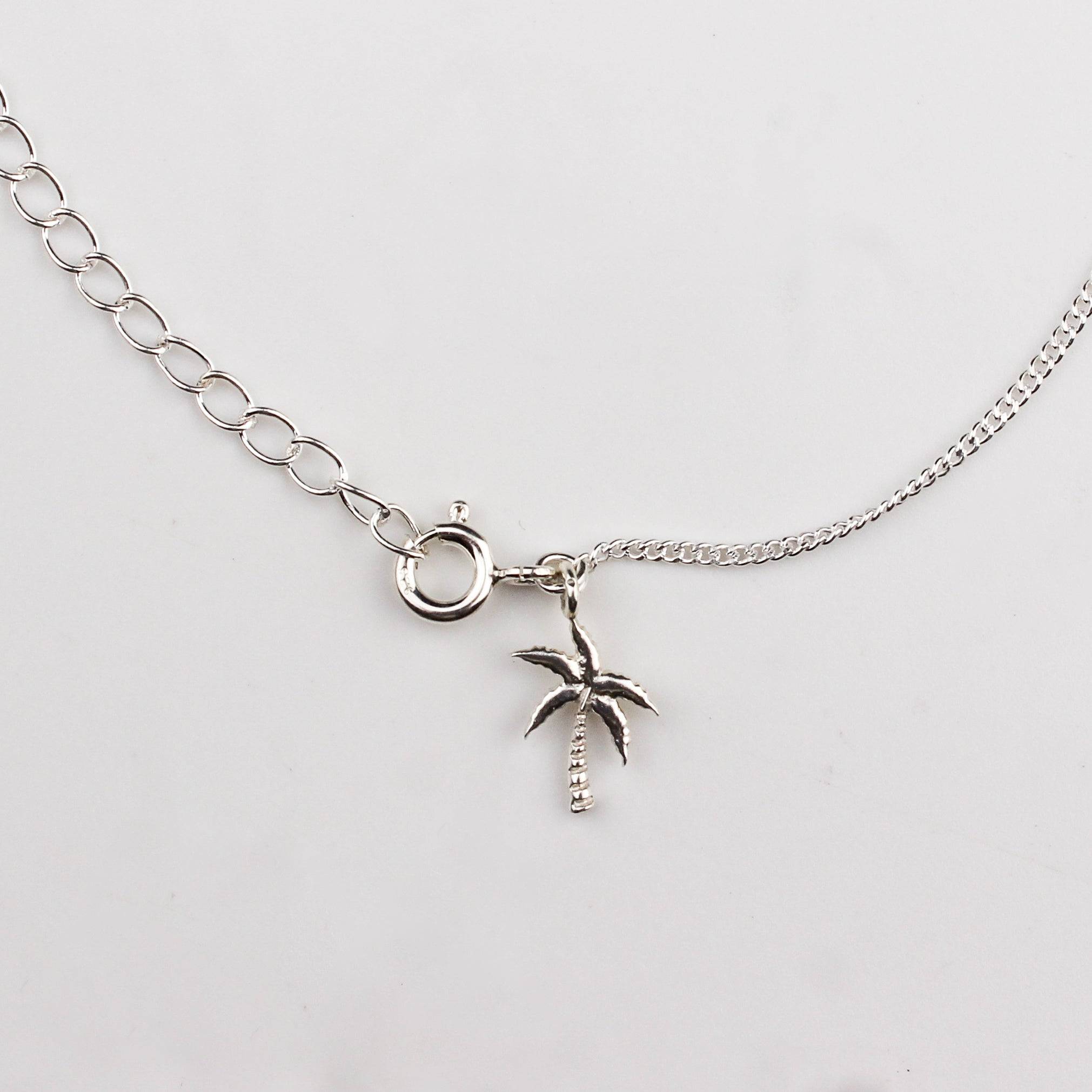 Close-up of silver coconut tree charm anklet detailing