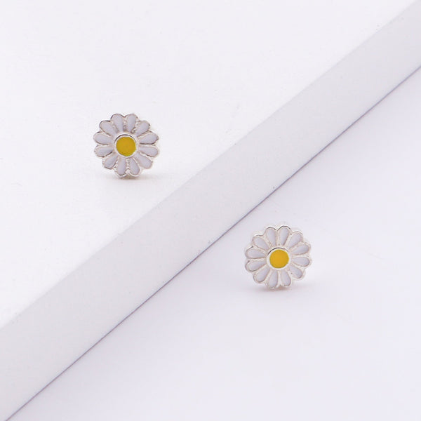 Close-up of daisy enamel stud earrings on white background