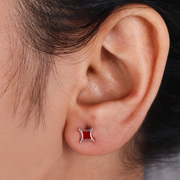 Woman wearing star enamel stud earrings, close-up of ear jewelry