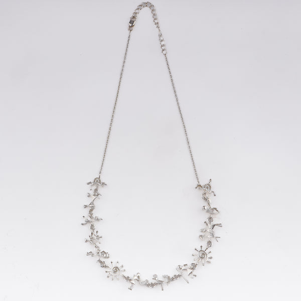 Close-up of silver Warli motif necklace with intricate tribal symbols