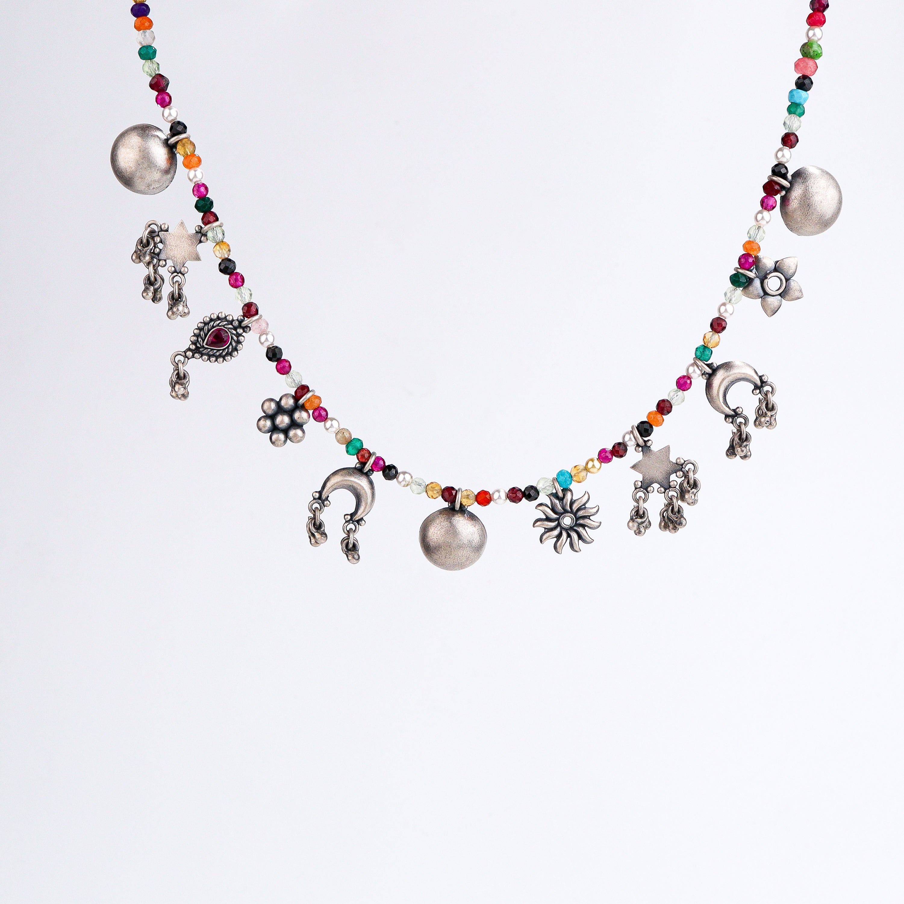 Close-up of silver charm motifs and multicolour stone detailing