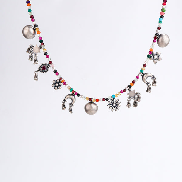 Close-up of silver charm motifs and multicolour stone detailing