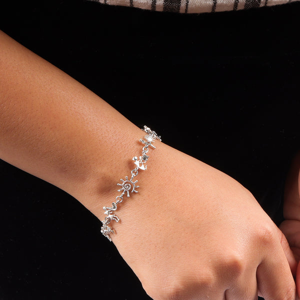 Silver Warli motif bracelet on wrist, tribal art jewelry, handcrafted silver accessory