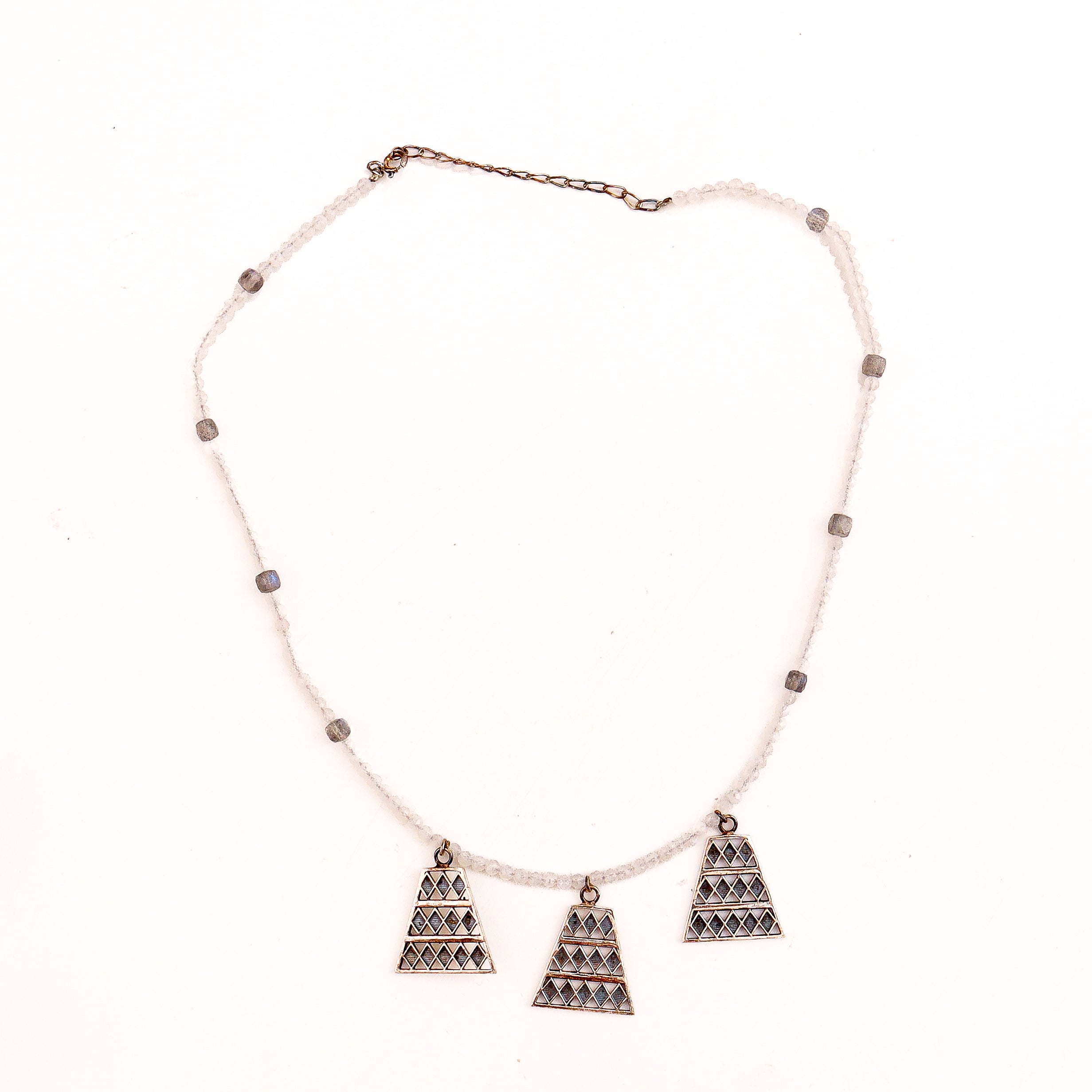 Silver trapezoid pendant necklace with beaded chain on white background
