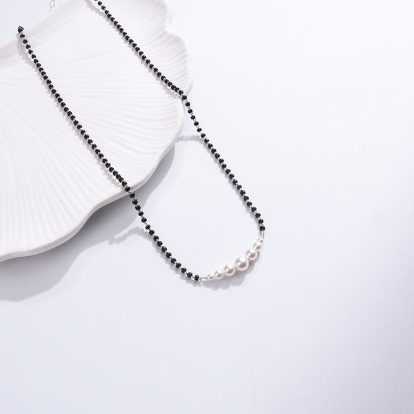 Minimal Pearls Silver Mangalsutra with black beads and pearl accents on white ceramic dish