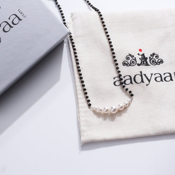 Minimal Pearls Silver Mangalsutra with black beads and white pearls on a jewelry pouch