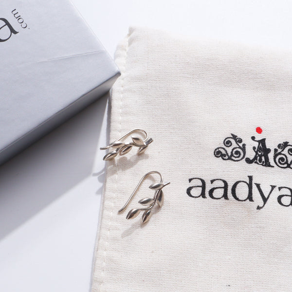 Silver Leaf Earcuffs earrings on fabric with packaging