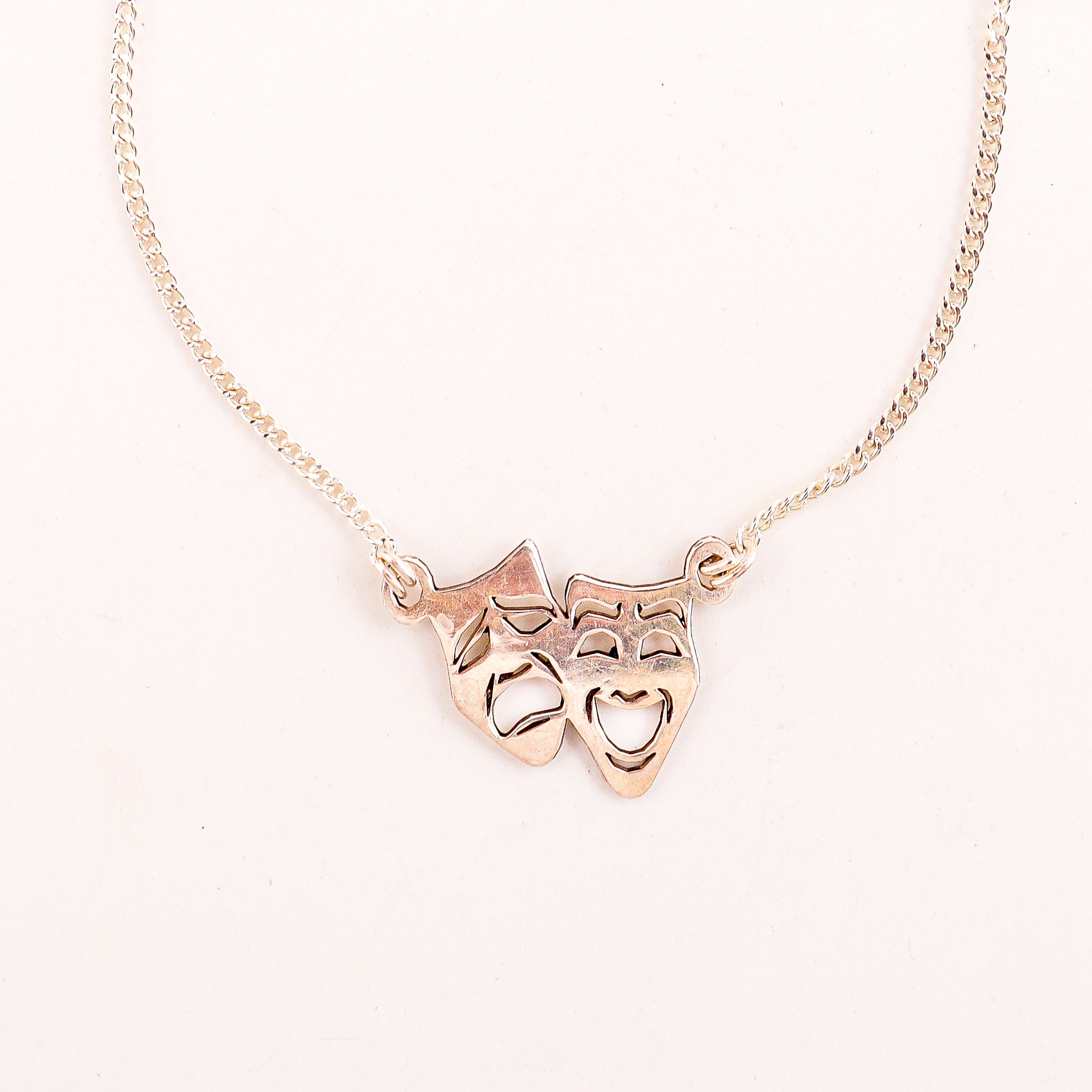 Detail shot highlighting polished silver drama masks finish