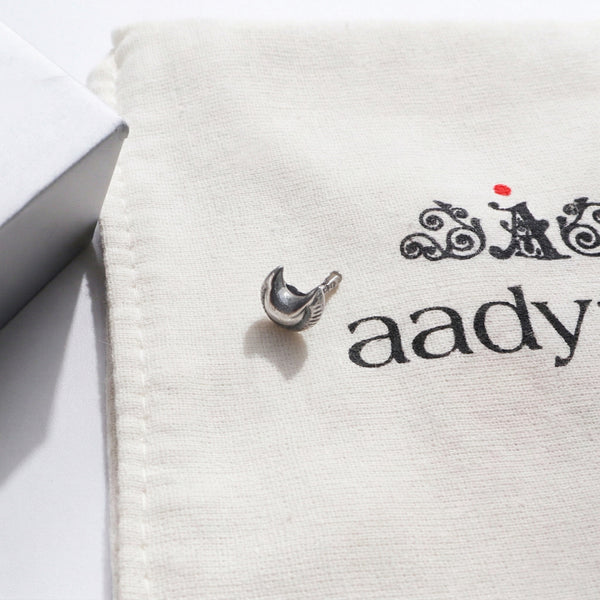 Silver textured Chandrakor nose pin on branded jewelry pouch