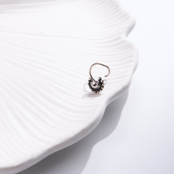 Silver nose pin on white ceramic dish