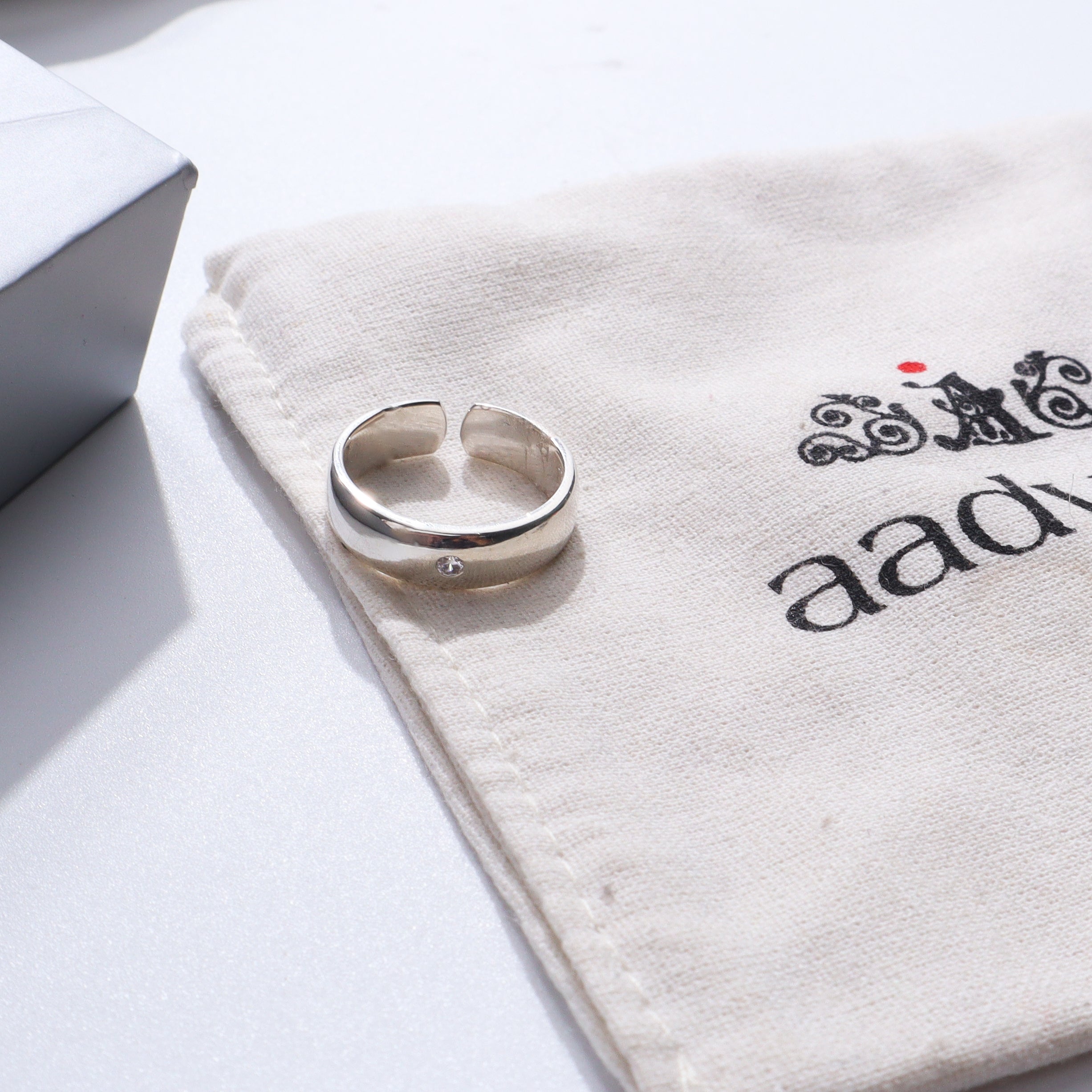 Silver ring with CZ stone on white fabric