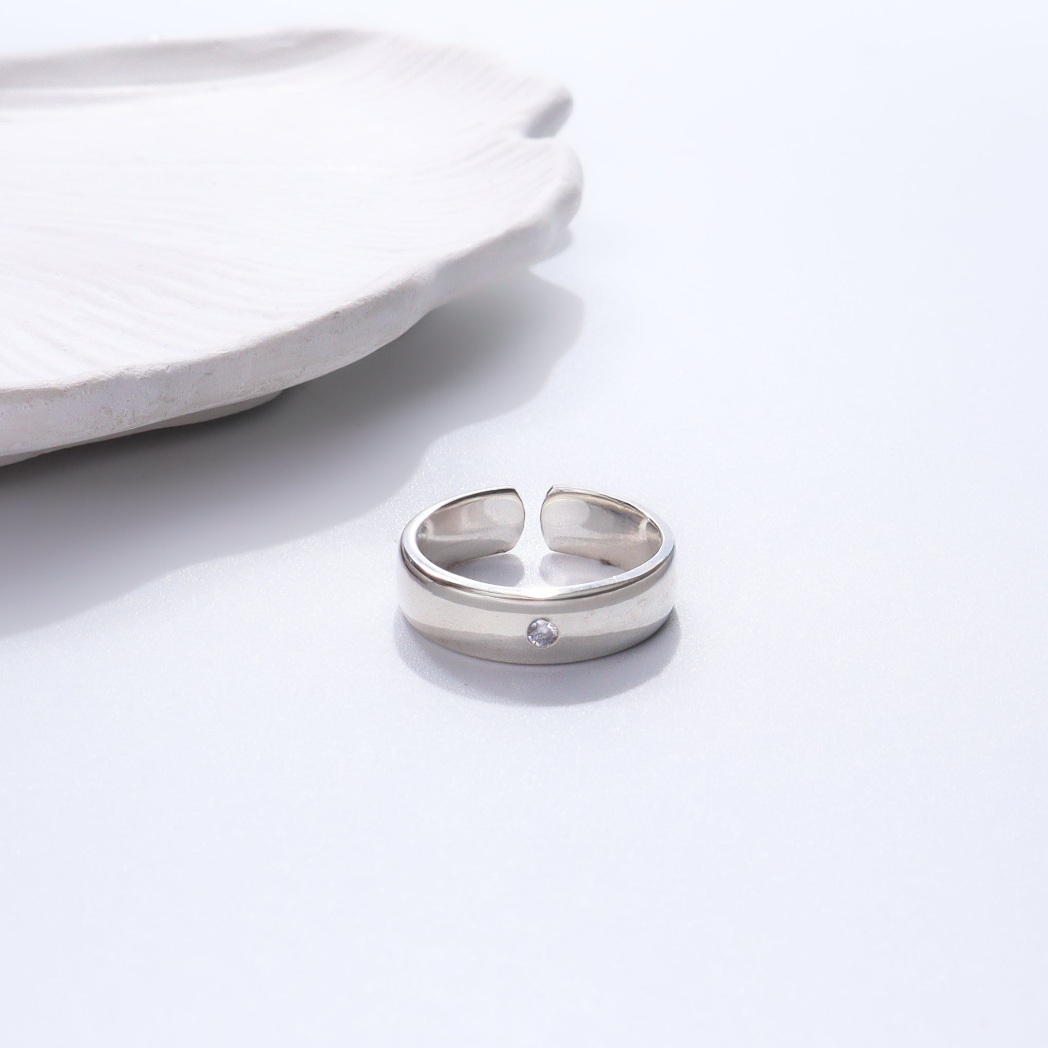 Silver ring with CZ stone on white background