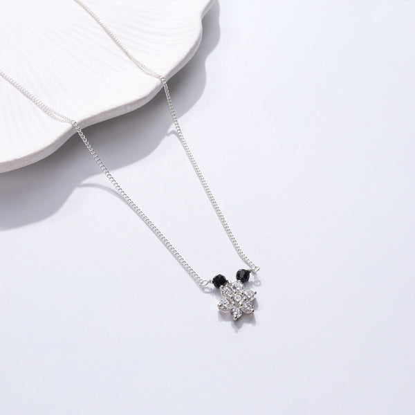 Silver necklace with black beads and floral pendant