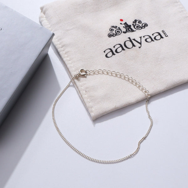 Silver chain bracelet on white fabric with Aadyaa logo