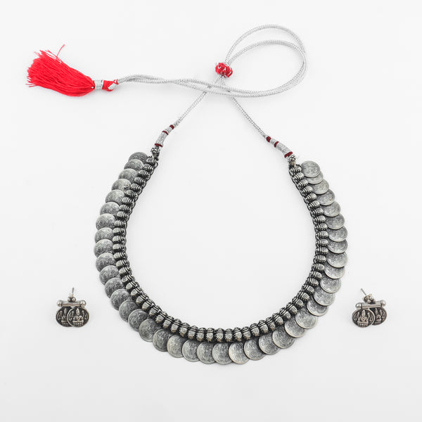 Silver coin necklace with red tassel on white background