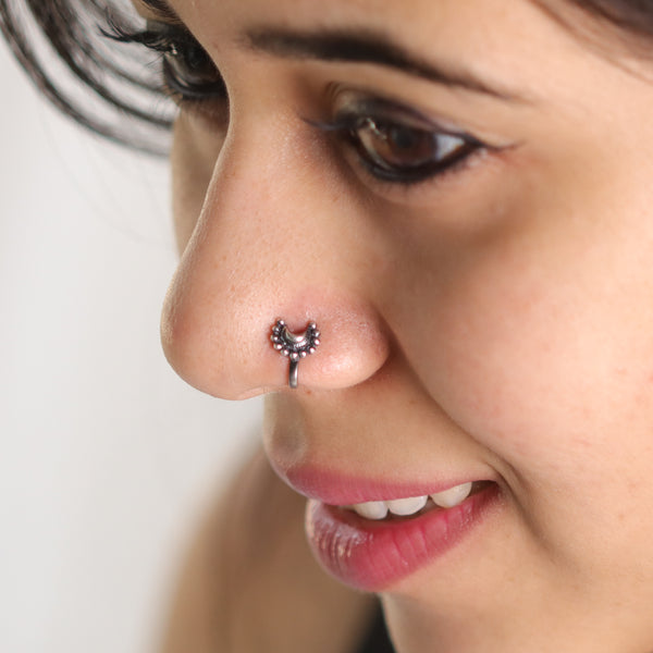 Small silver nose pin on nose