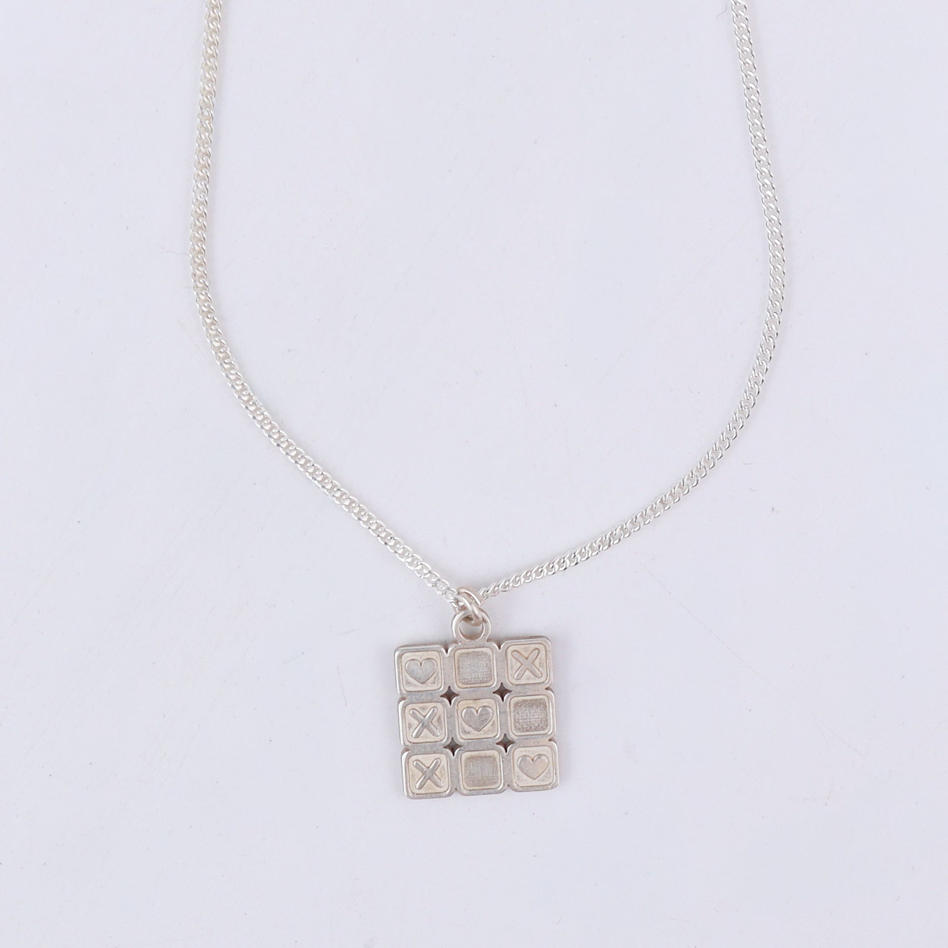 wear big tic tac toe pendant necklace for statement styling
