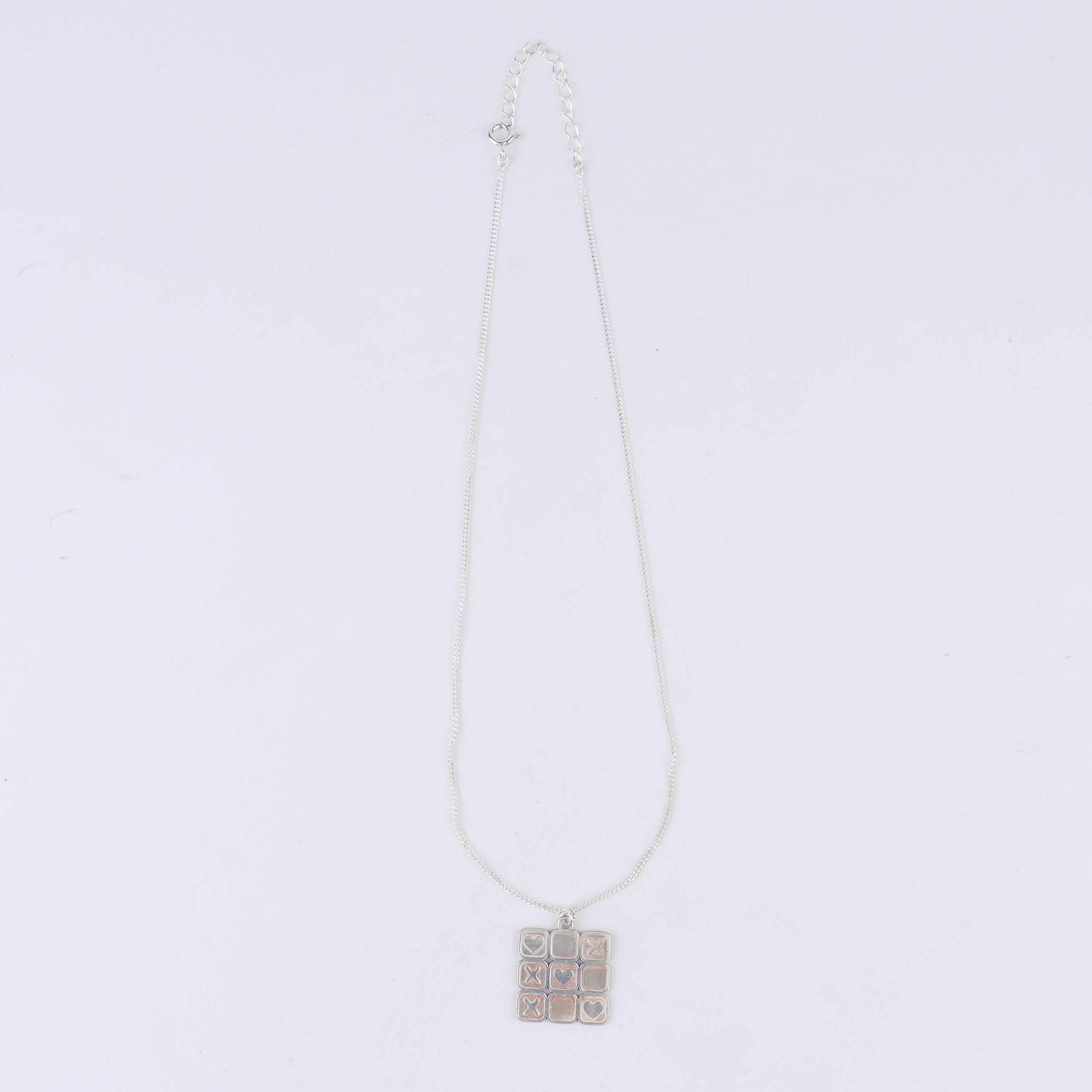 Tic tac toe silver pendant styled with modern outfit
