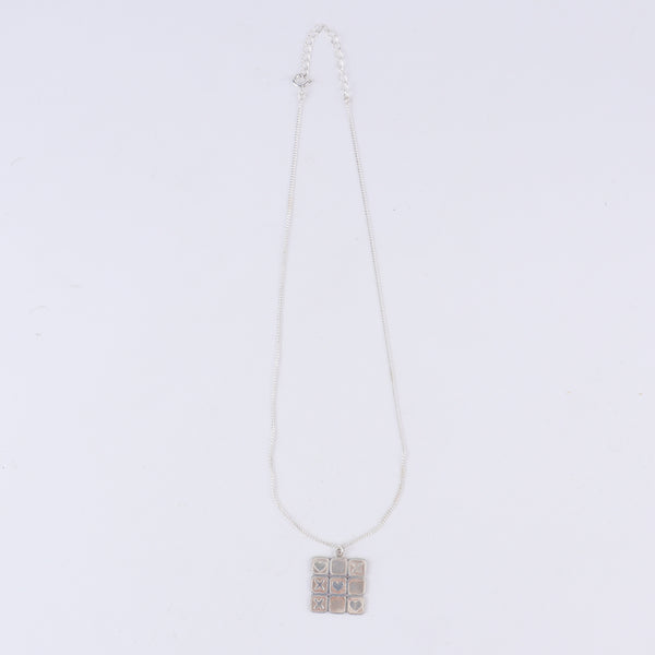 Tic tac toe silver pendant styled with modern outfit