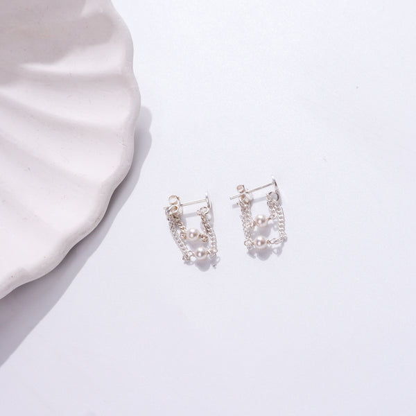 Silver pearl earrings with chain design