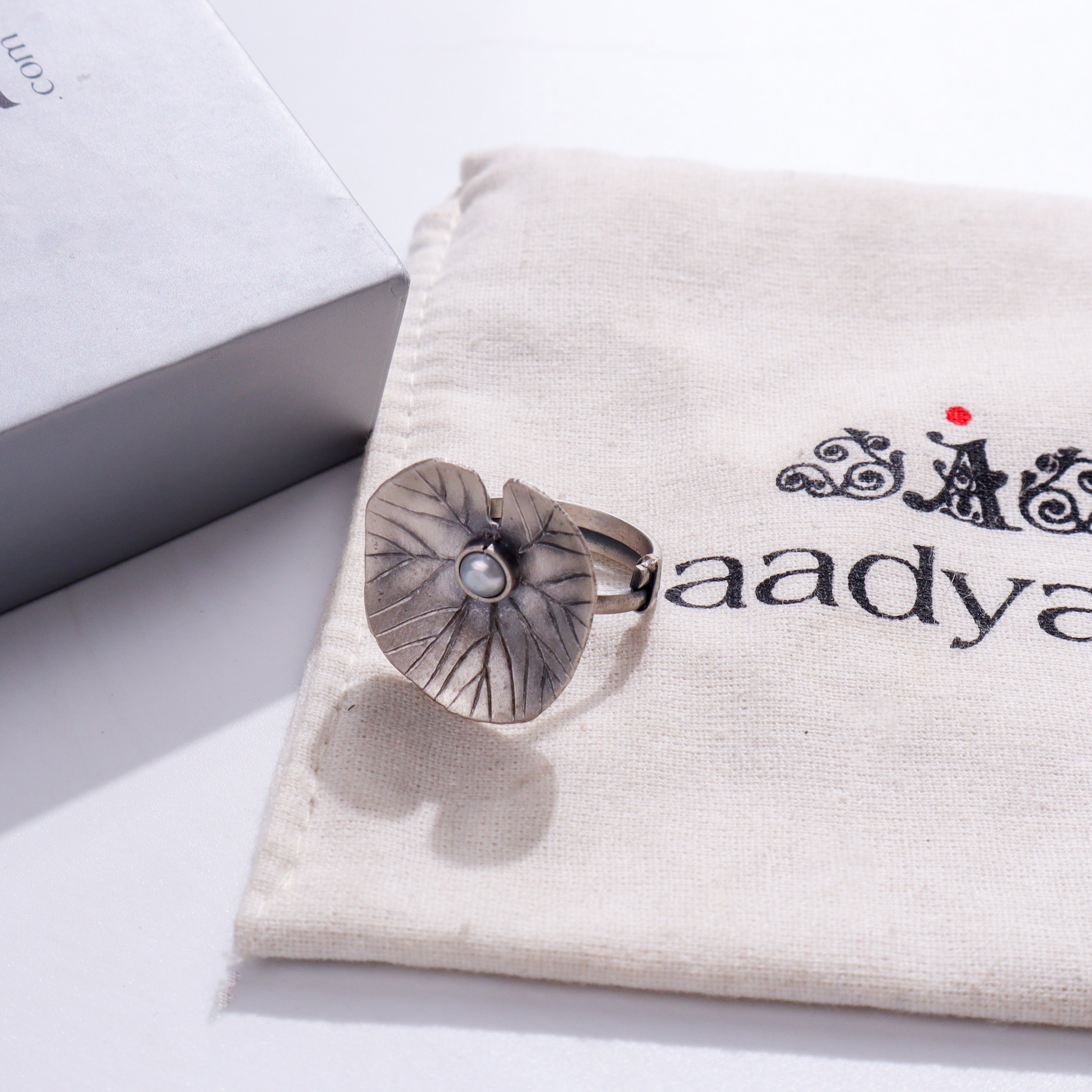 Silver flower brooch on white fabric