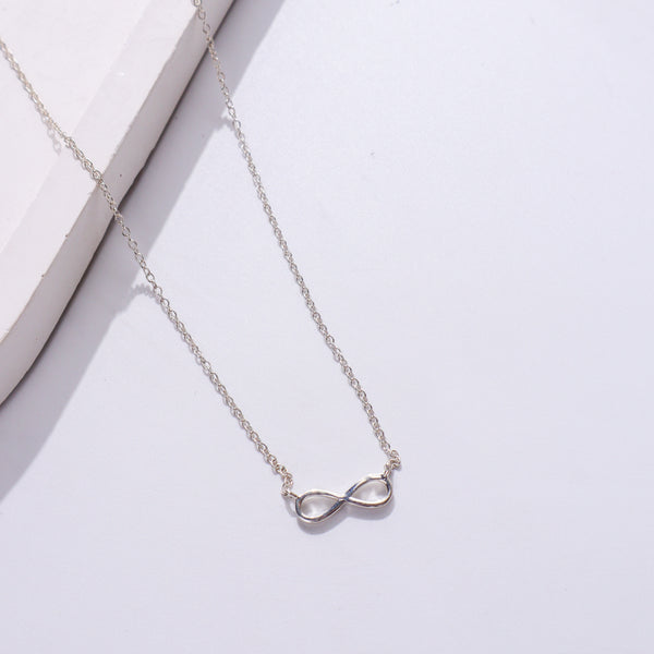 Silver infinity necklace on white background