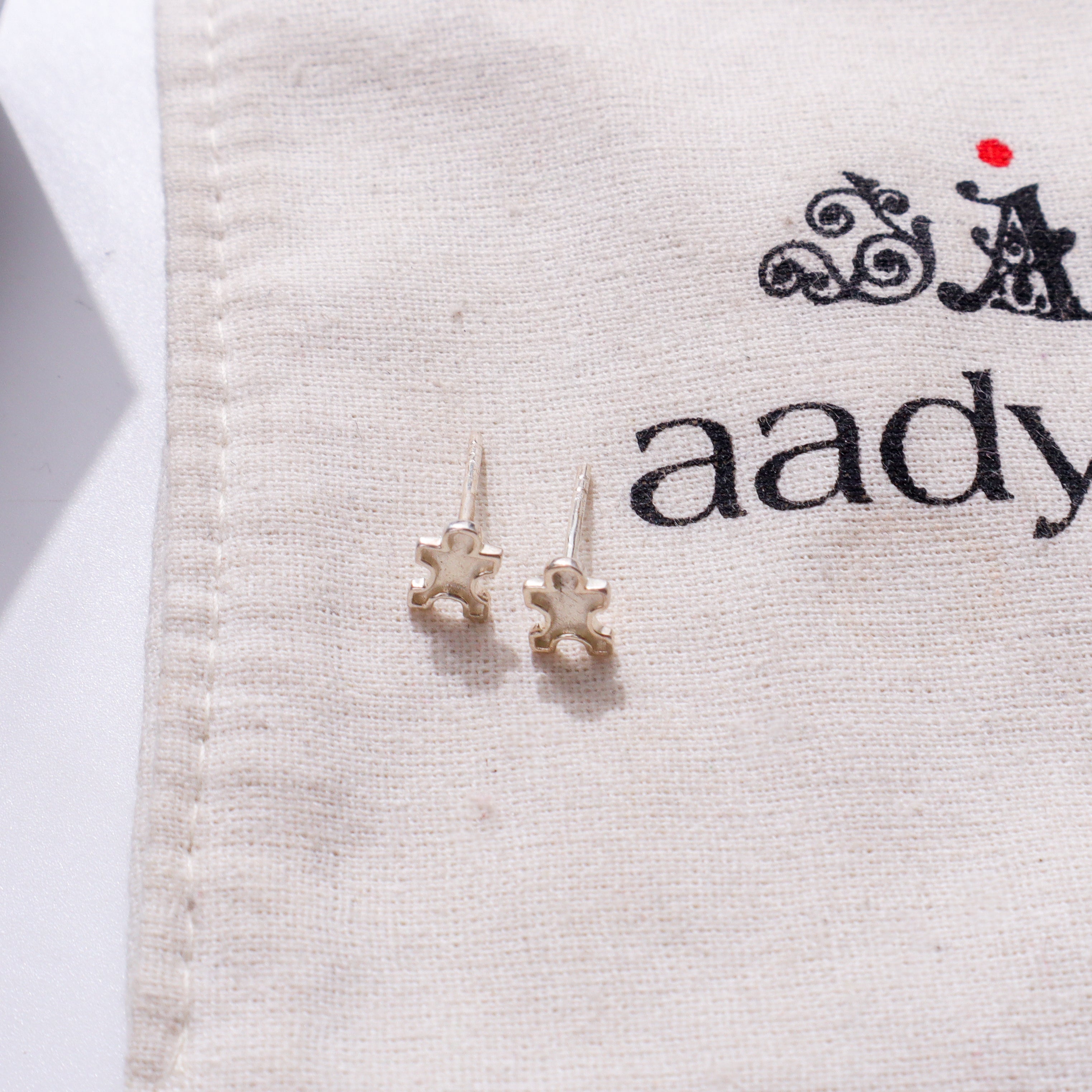 Silver jigsaw puzzle earrings on fabric