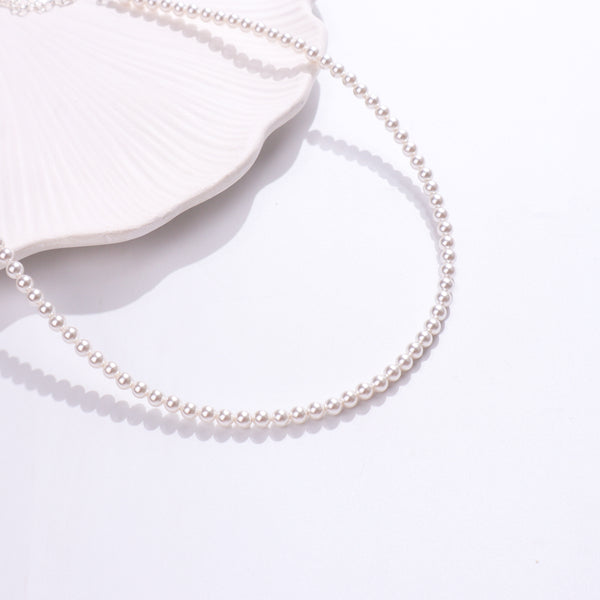 White pearl beaded necklace on white shell