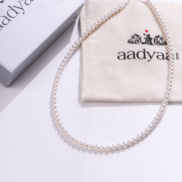 White pearl beaded necklace on fabric pouch