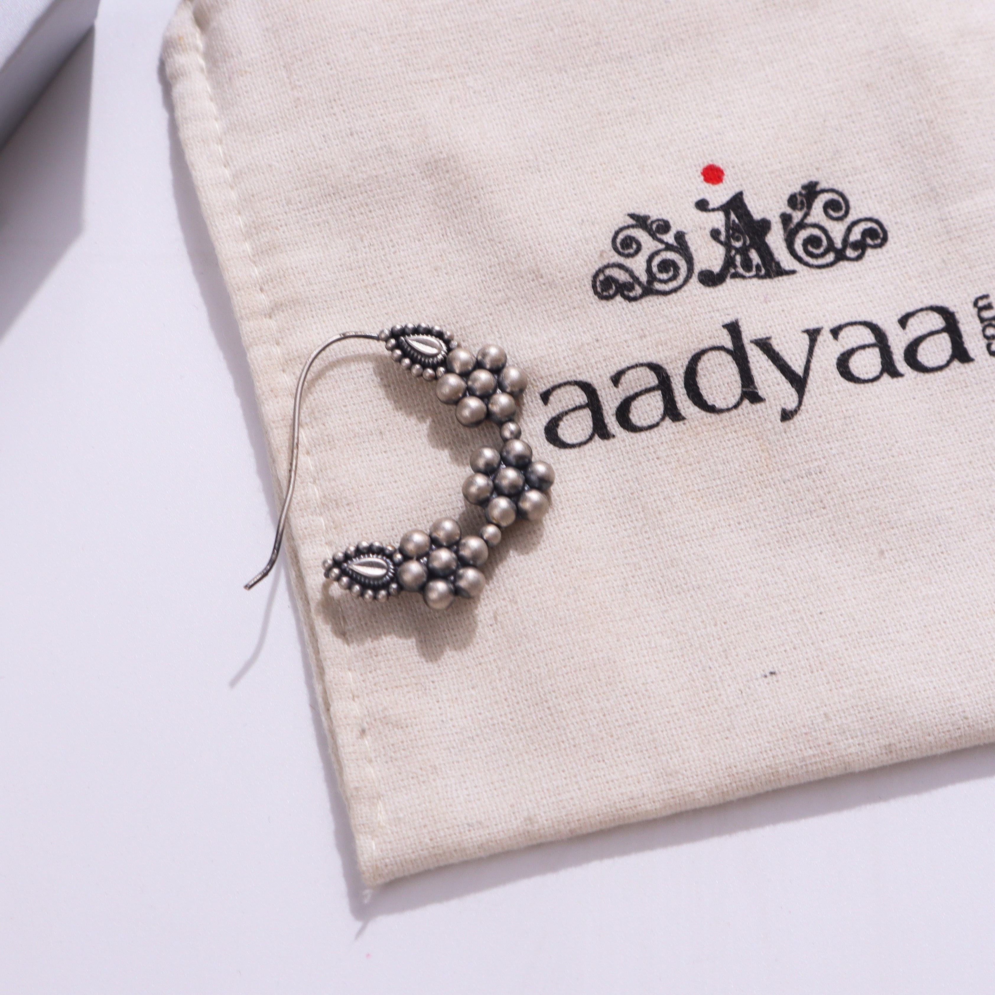 Silver Nath jewelry on fabric with logo