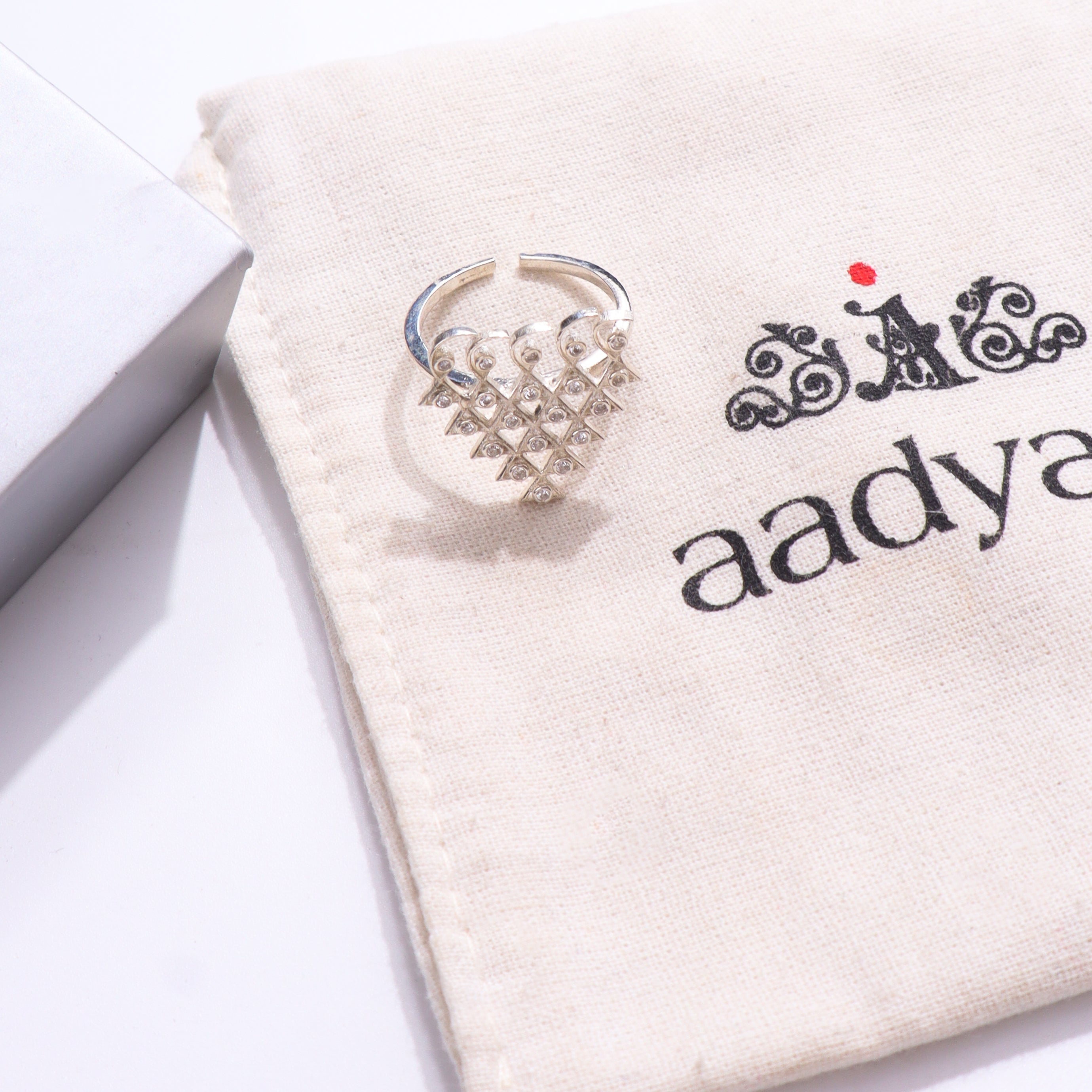 Silver Saraswati ring with cubic zirconia on beige fabric