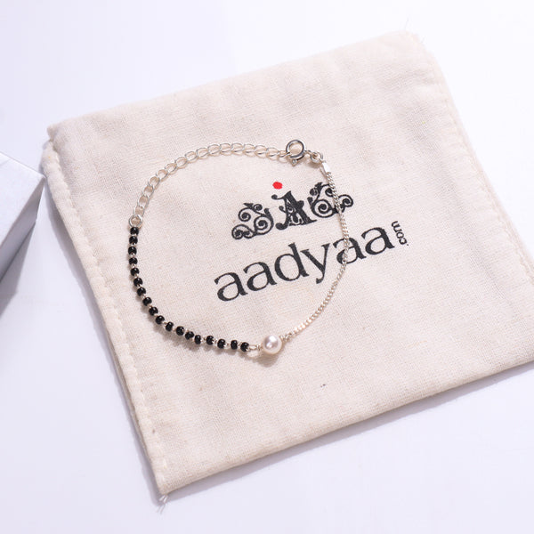 Silver Pearl Mangalsutra Bracelet with black beads on beige fabric