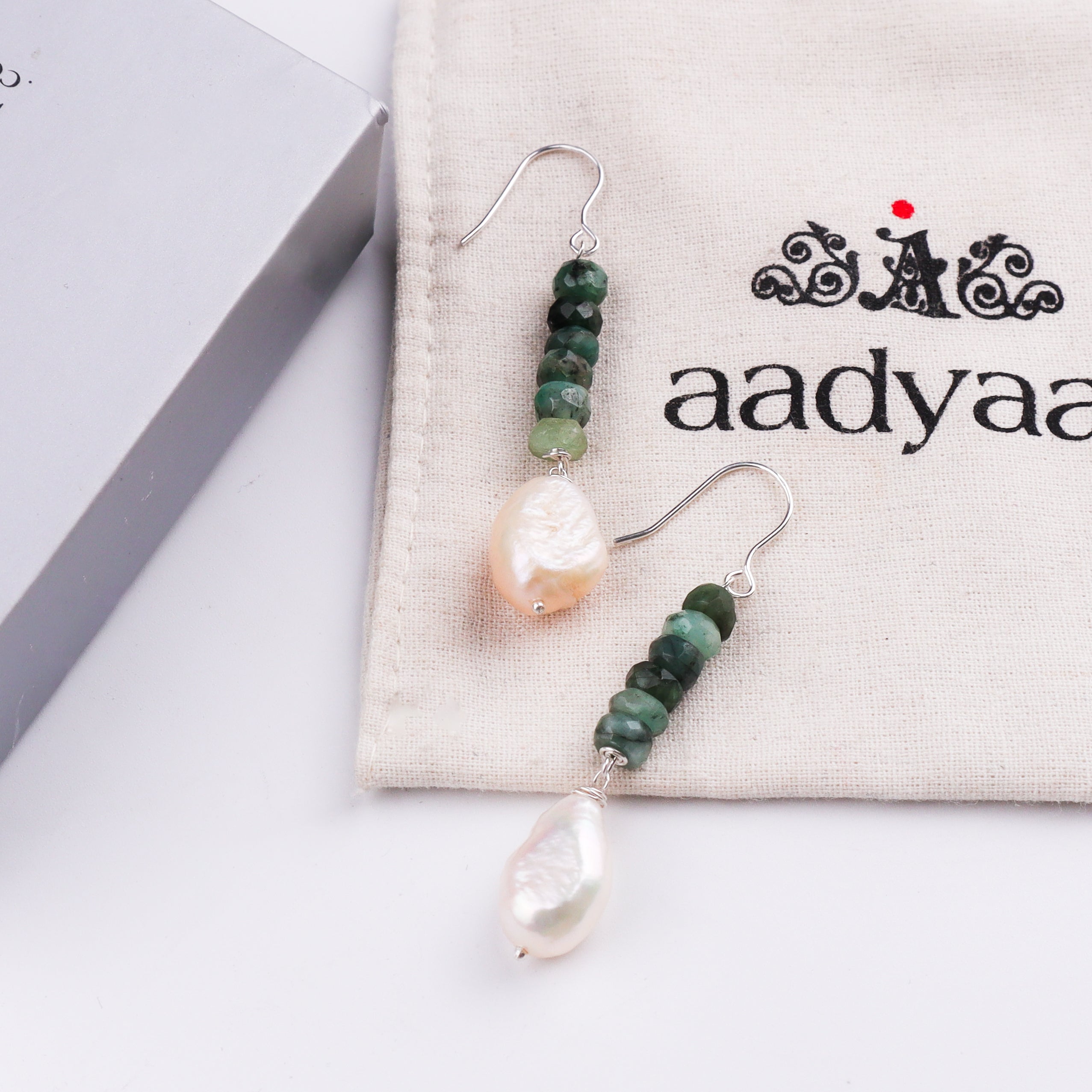 Silver hook earrings with green beads and pearl drops on white background