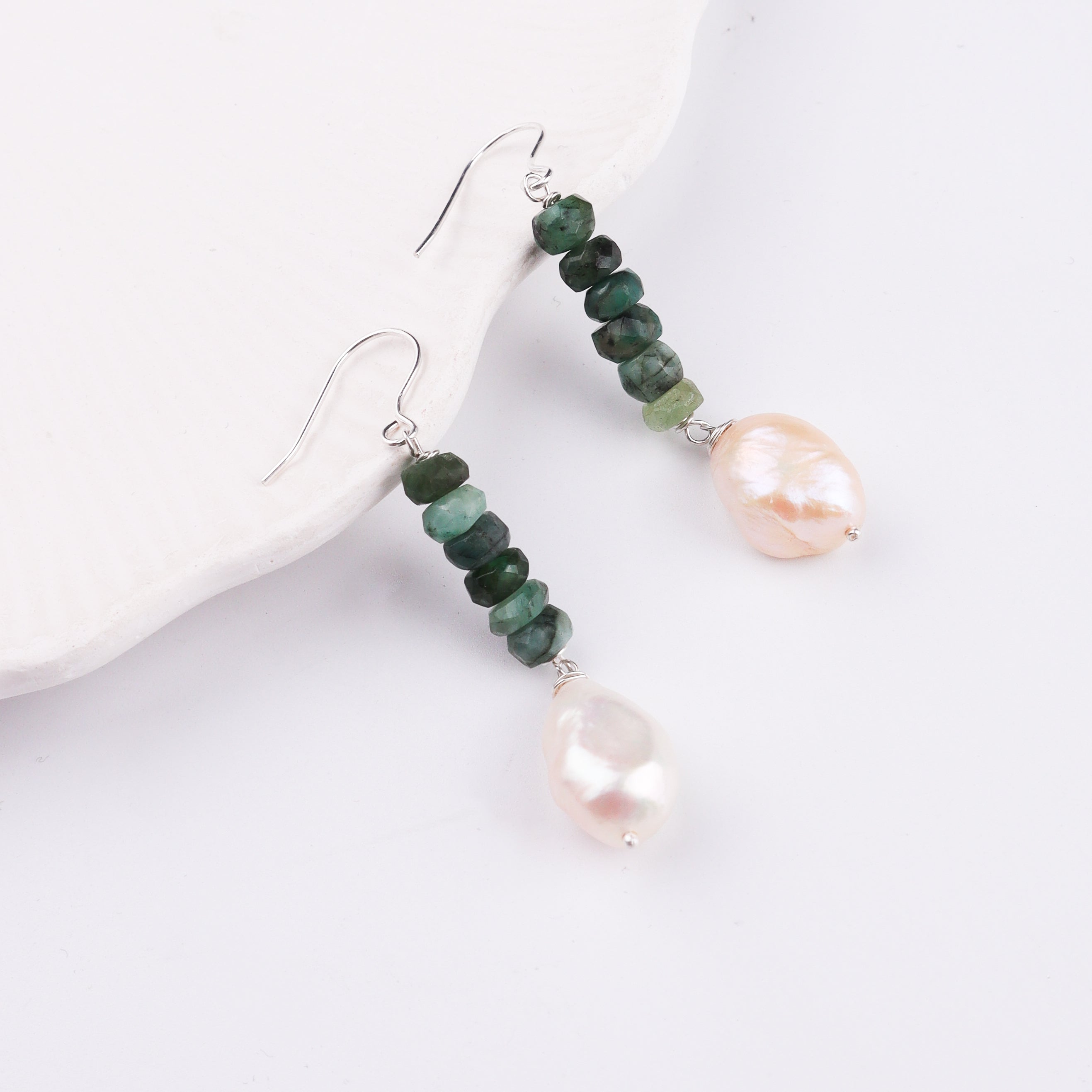 Silver hook earrings with green beads and pearl drops on white backdrop
