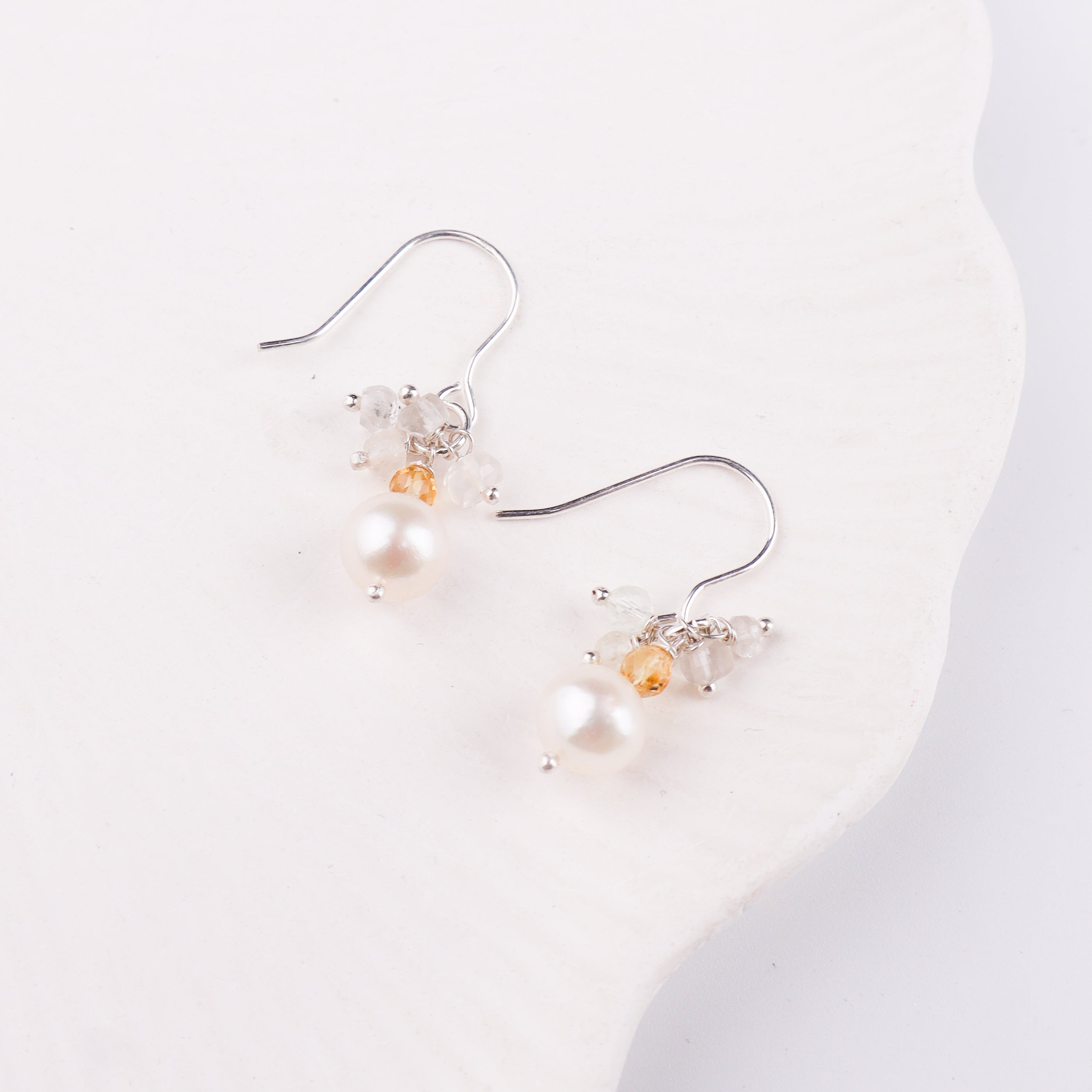 Pearl and crystal drop earrings on white background