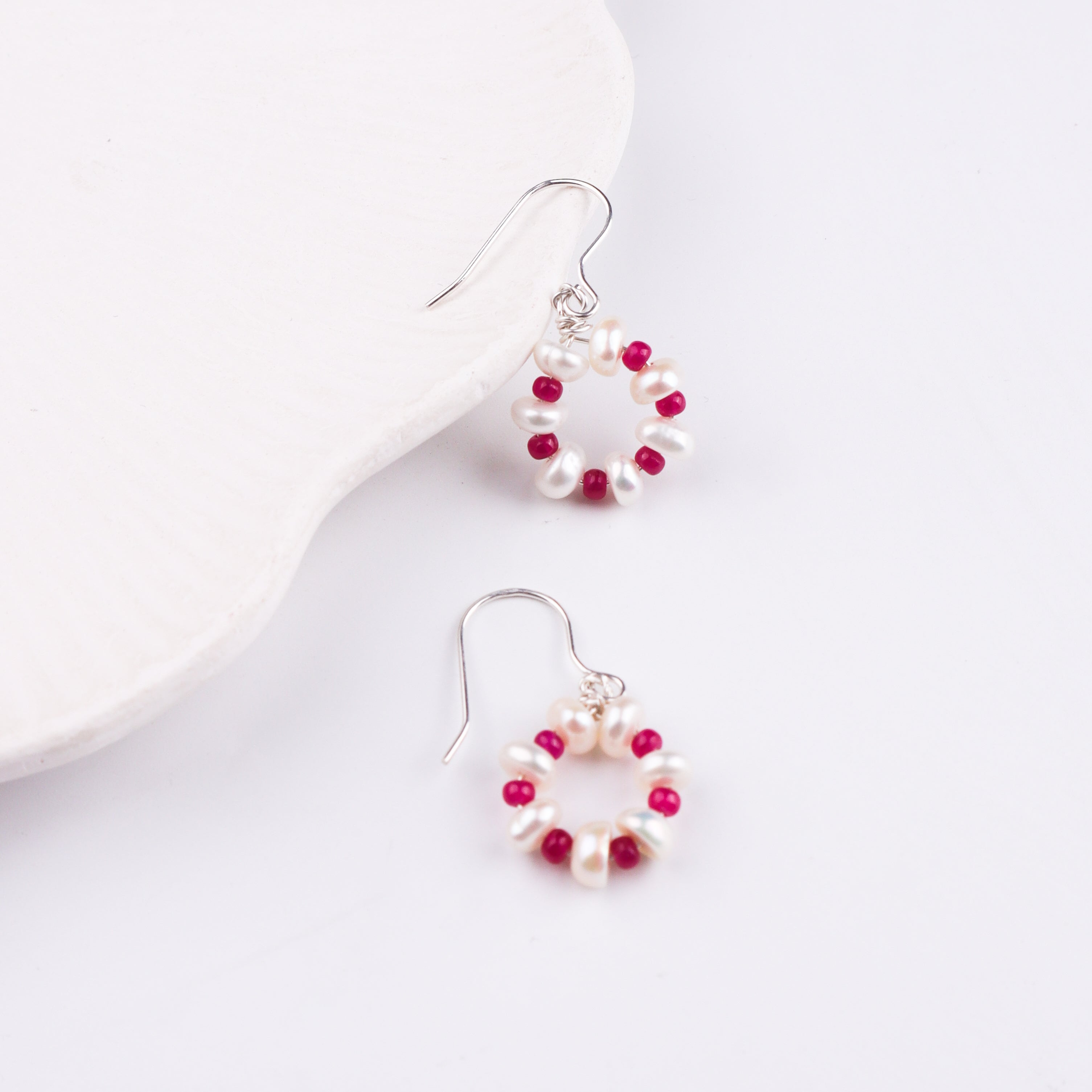Pearl and ruby earrings displayed on jewelry box
