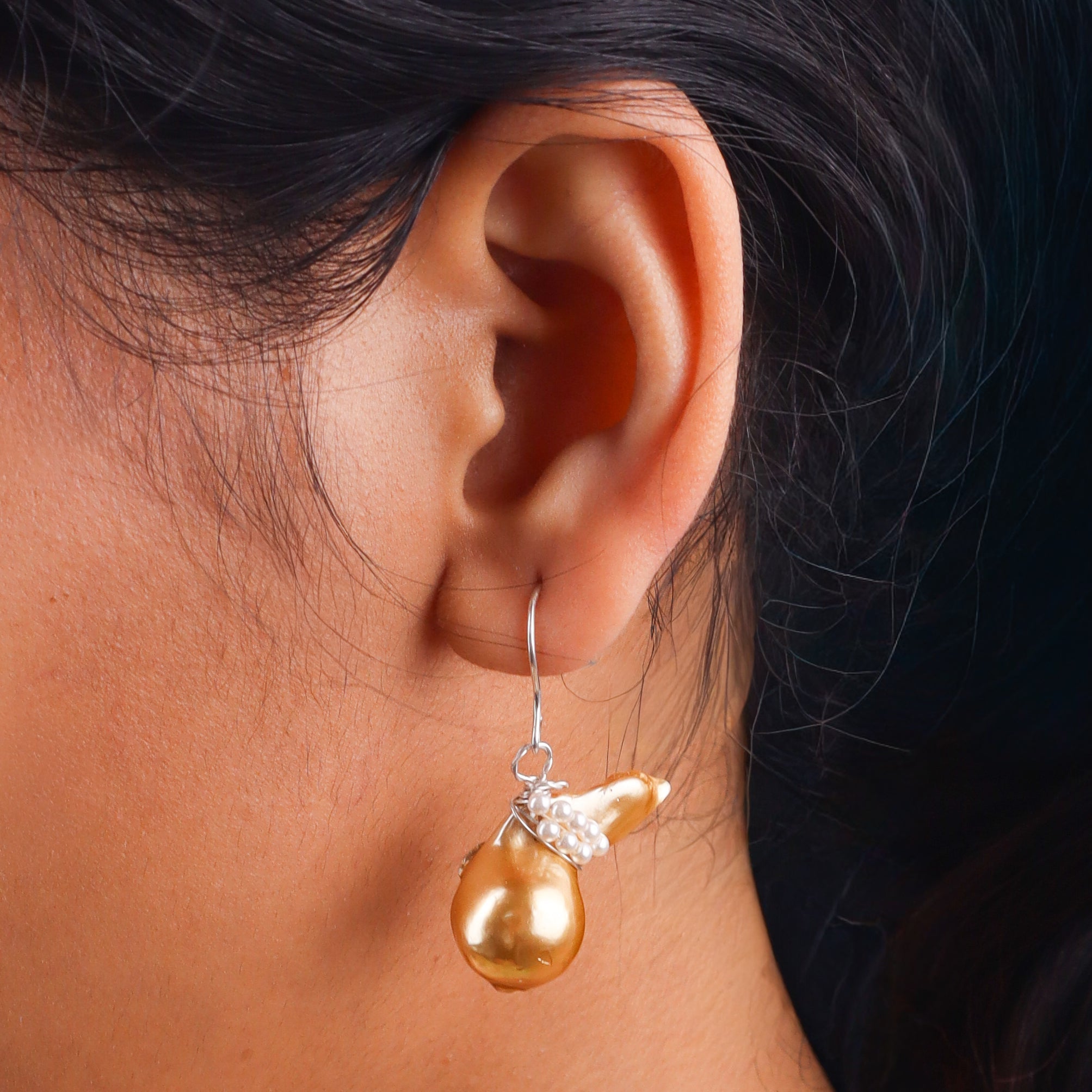 Close-up of pearl and gold earrings on white background