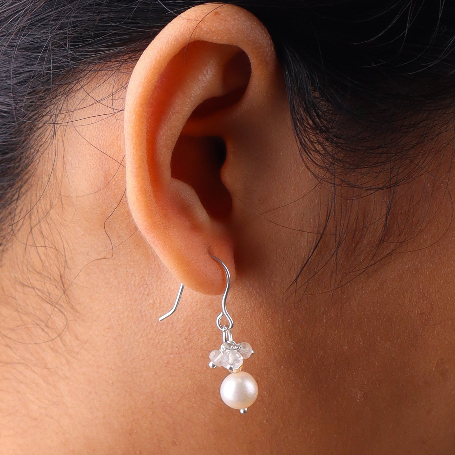 Close-up of pearl and crystal drop earrings on white background