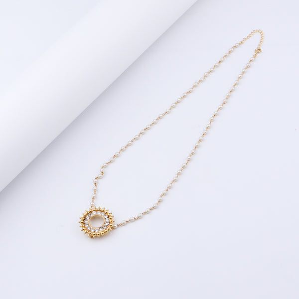 Close-up of pearl and gold chain with pendant detail